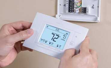 Electrician Repairing Thermostat